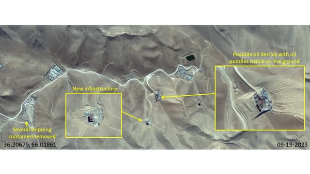 A possible oil derrick (drilling tower) has been constructed in the center, with possible oil puddles on the ground around it. A clearing just below the derrick has also been developed with new constructions on it.